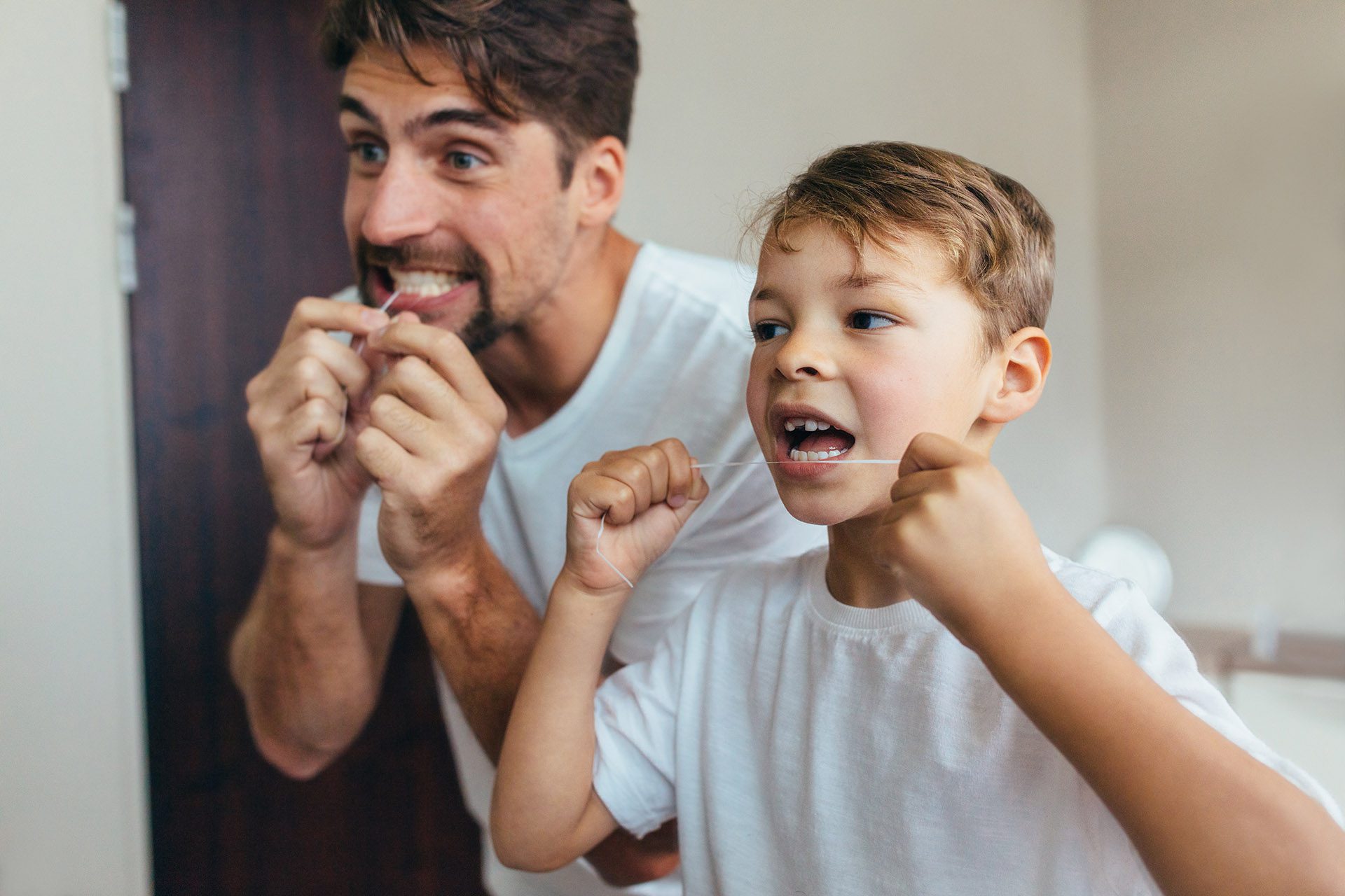 Dad and son flossing - Ideal Image