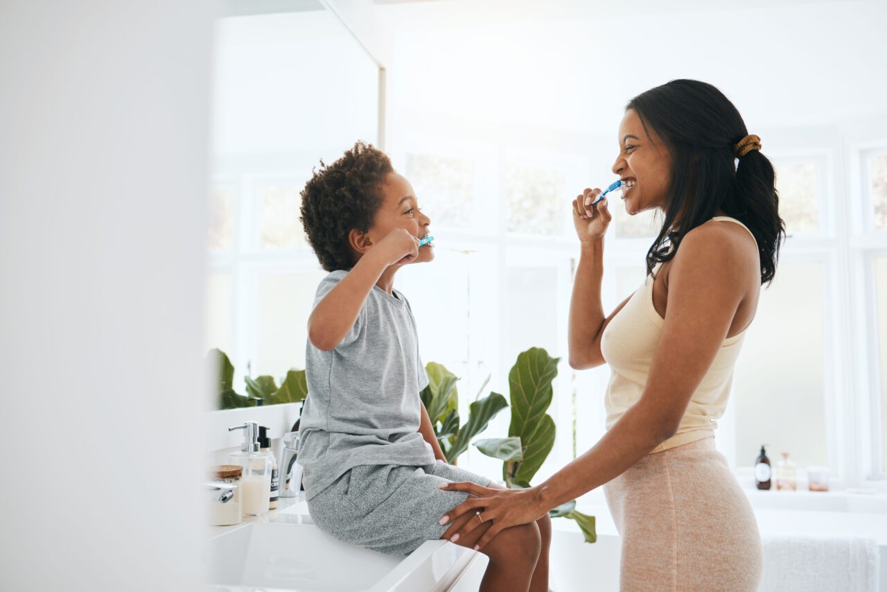 mom and child brushing teeth together
